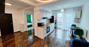 a kitchen with white cabinets and a table with chairs at Exclusive location in West Bay