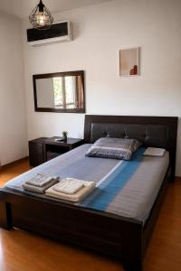 a large bed in a bedroom with two towels on it at Among the pines in Katakolo