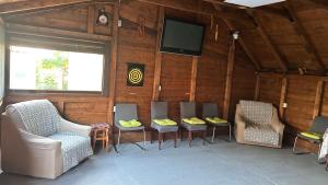 a room with a group of chairs and a flat screen tv at Casa Vera in Corbu