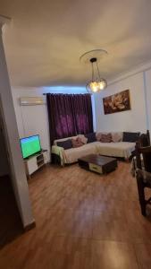 a living room with a couch and a tv at F3 de luxueux in Bejaïa