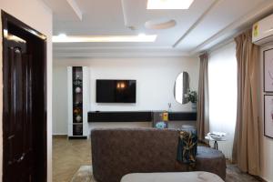 a living room with a couch and a tv at Sunrise Cave in Oyibi