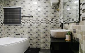 a bathroom with a white tub and a sink at Sunrise Cave in Oyibi