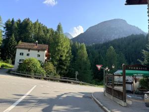a road with a building on the side of a mountain at Hotel Alp Sur in Mühlen