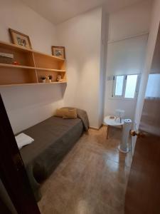 a small bedroom with a bed and a table at Casa turística AZAHAR in Villablanca