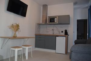 a kitchen with a counter and a microwave and a couch at El patio de Carmen in Hornachuelos