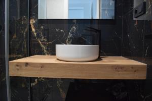 a white bowl sitting on a wooden shelf in a bathroom at El patio de Carmen in Hornachuelos +11 photos