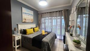 a bedroom with a bed with a yellow stuffed animal on it at Topanga 17 in Uvongo Beach +68 photos