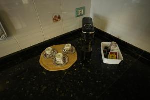 a table with a cell phone and two cups on it at Casa Dolce Armonia in Augusta