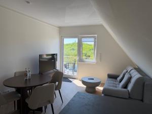 a living room with a couch and a table at BeachHus 35, Whg 4 in Sankt Peter-Ording