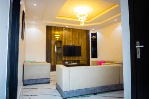 a living room with a couch and a tv at BBB Luxury Apartment in Amuwo +1 photo