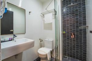 a bathroom with a sink and a toilet and a shower at inHotel Inanam in Kota Kinabalu