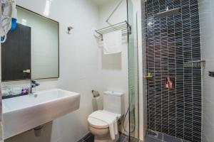 La salle de bains est pourvue d'un lavabo, de toilettes et d'une douche. dans l'établissement inHotel Inanam, à Kota Kinabalu