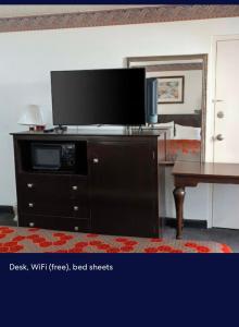 a flat screen tv on top of a wooden dresser at EXECUTIVE INN & SUITES HIGHWAy US 59 in Lufkin