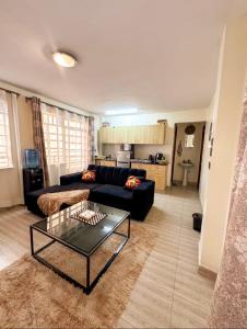 a living room with a black couch and a table at Stylish Ngong Retreat with Balcony & Rooftop Lounge The Moon Stays in Ngong