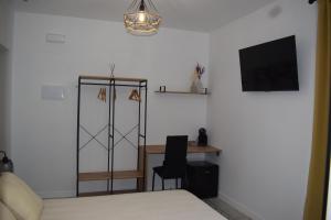 a bedroom with a desk and a tv and a bed at El patio de Carmen in Hornachuelos