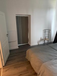 a bedroom with a bed and a chair next to a window at Ferienwohnung Calluna in Faßberg
