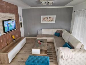 a living room with a couch and a tv at Rooms Mario in Međugorje