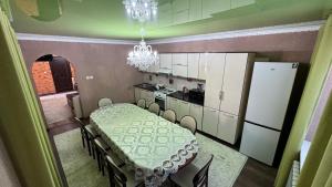 a dining room with a table and a kitchen at Rinat Guest House in Pokrovka