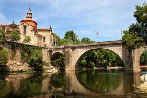 an old stone bridge over a river with a church at Alojamento Local Tamega in Amarante