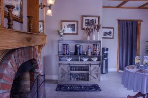 a living room with a brick fireplace and a table at Carmel Wayfarer Inn in Carmel