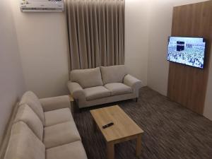 a living room with a couch and a tv at فيو بارك للاجنحة الفندقية in Al Kharj +5 photos