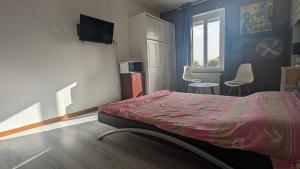 a bedroom with a bed and chairs and a television at Chambre studio in Sublaines +19 photos