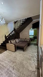 a living room with a couch and a staircase at Rinat Guest House in Pokrovka