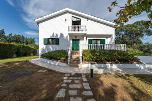 a white house with a green door and stairs at Onde a tranquilidade Reina in Recarei