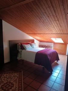 a bedroom with a bed with a wooden ceiling at Onde a tranquilidade Reina in Recarei