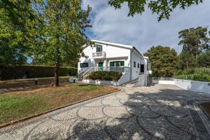 a white house with a tree and a driveway at Onde a tranquilidade Reina in Recarei