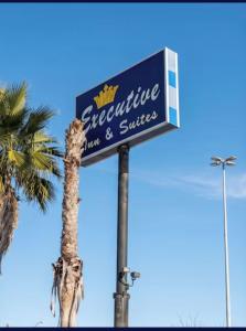 a sign for a restaurant and a palm tree at EXECUTIVE INN & SUITES HIGHWAy US 59 in Lufkin +10 photos