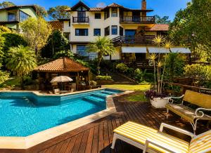 a house with a swimming pool in front of a house at Chalé Guararema in Petrópolis