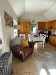 a living room with a leather couch and a table at Cottage in the Dublin mountain in Dublin