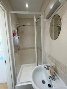 a white bathroom with a sink and a shower at Cottage in the Dublin mountain in Dublin +19 photos