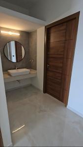 a bathroom with a sink and a wooden door at Cherry Bloom in Chikmagalūr