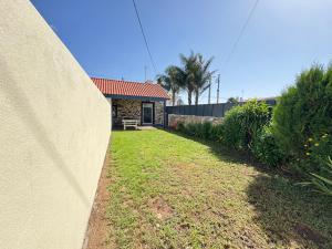 a wall next to a yard with a house at Ribeira do Forno 2 in Adaúfe +4 photos