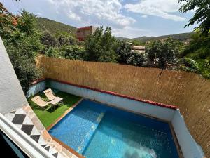a swimming pool on the side of a house at Dar Idurar in Imouzzer du Kandar