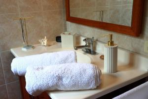 a bathroom sink with two white towels on it at Casa M&B in Las Galeras +24 photos