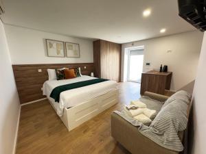 a bedroom with a bed and a couch in it at Ribeira do Forno 2 in Adaúfe