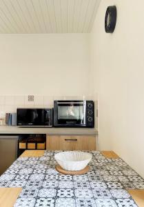 a kitchen with a microwave and a bowl on a table at Bienvenue dans le Perche in Sainte-Céronne-lès-Mortagne