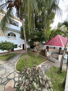 a house with a palm tree in front of it at Villa Tuffah in Watamu