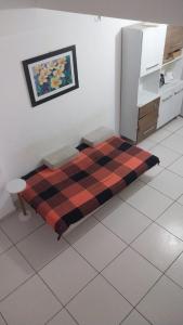 a bed in a room with a plaid blanket on the floor at Flat Shopping Amarração N - 129 in Luis Correia +22 photos