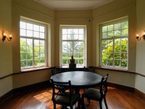 a dining room with windows and a table and chairs at Graystone Bungalow by Seven Angels in Haputale