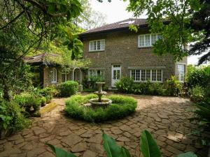 a brick house with a fountain in front of it at Graystone Bungalow by Seven Angels in Haputale
