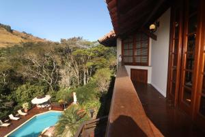 a balcony of a house with a swimming pool at Chalé Guararema in Petrópolis