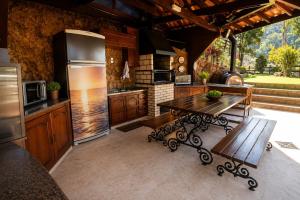 a kitchen with a wooden table and a stove at Chalé Guararema in Petrópolis