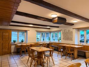 a restaurant with wooden tables and chairs and windows at Hotel Alp Sur in Mühlen