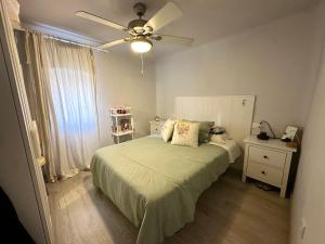 a bedroom with a bed and a ceiling fan at Apartamento próximo al palacio de congresos in Granada