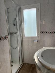 a bathroom with a shower and a sink and a window at Apartamento próximo al palacio de congresos in Granada