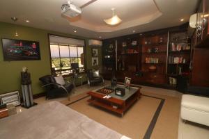 a living room filled with furniture and a tv at Chalé Guararema in Petrópolis